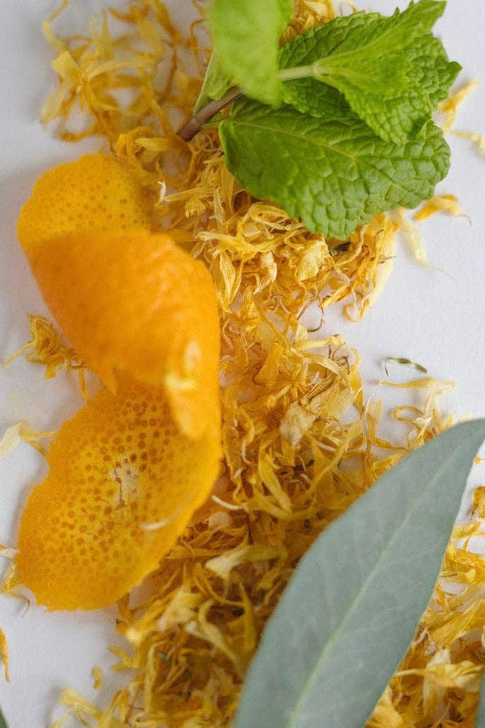 Dried blood orange peel with green leaves on a white background