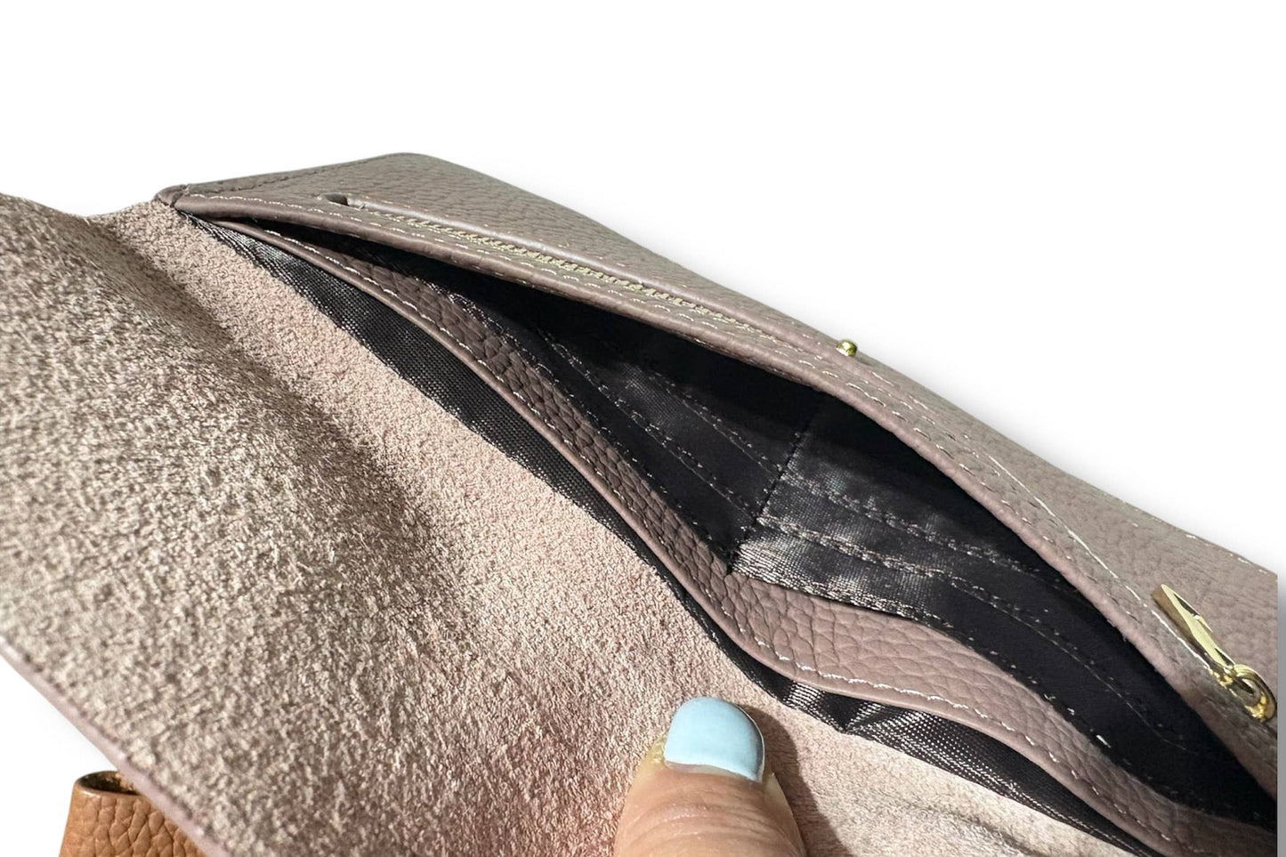 Close-up of a taupe textured leather wallet from Armoir being opened to show a black interior pocket, with a finger pointing inside.