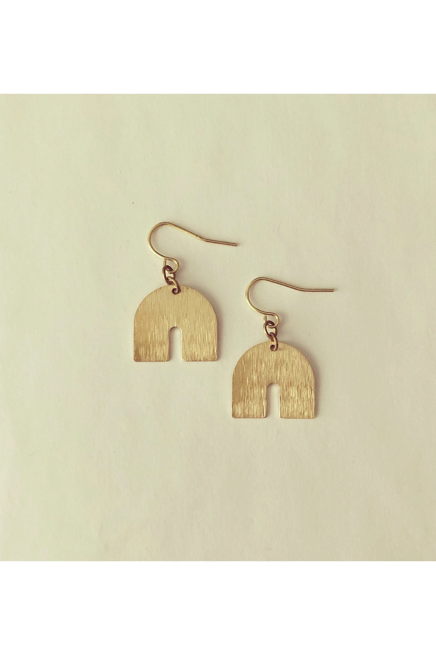 Juuk earrings by Darlings of Denmark; unplated raw brass; textured arches; dangle earrings; flat lay