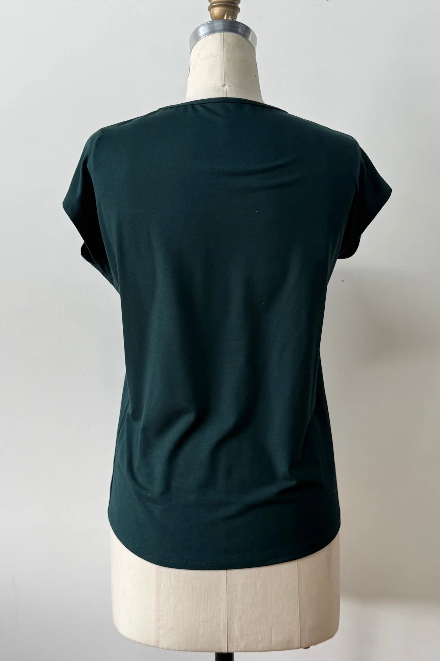 A back view of the Eowyn T-Shirt by Kollontai in Green is shown on a white mannequin against a white 