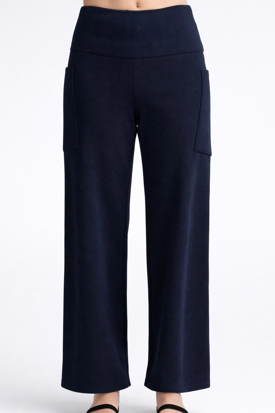 The Lorenzo Pants by Kollontai, in a ribbed navy corduroy-like fabric with a wide pull on waist, straight legs, and large patch pockets, are shown on a mannequin against a white background. 