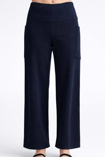 The Lorenzo Pants by Kollontai, in a ribbed navy corduroy-like fabric with a wide pull on waist, straight legs, and large patch pockets, are shown on a mannequin against a white background. 