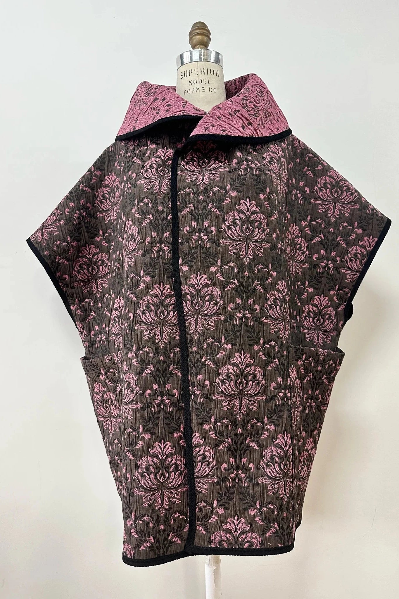 The Abigail Vest by Kollontai in Pink Jacquard is show on a mannequin in front of a white background 