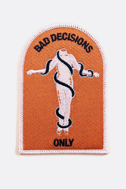 An arched embroidered patch from  Badaboöm Studio with a peach-orange background, featuring a white female figure wrapped in a black snake, with the text 'BAD DECISIONS' at the top and 'ONLY' at the bottom.