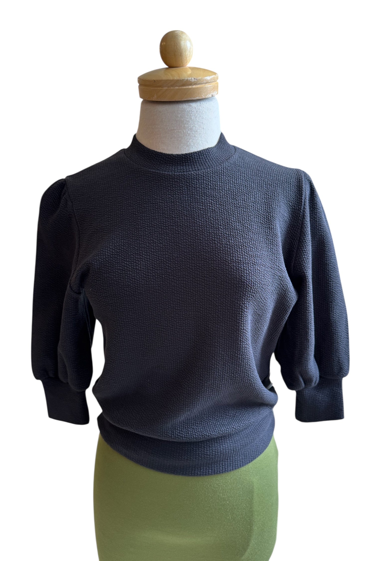 The Bridge Sweater by Allison Wonderland in Black, featuring elbow length sleeves and a ribbed neckline, cuff, and hem, is shown on a mannequin against a white background. 