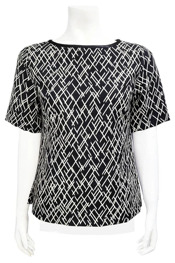 The Cecil Box Blouse by Mandala in Crosstown print is shown on a mannequin against a white background. It has a high neckline, wide 1/2 sleeves, and a side hem slit detail. 