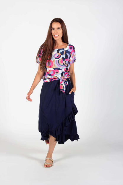 A woman wearing the Cameron Top and Catrina Skirt in Navy by Pure Essence standing in front of a white background