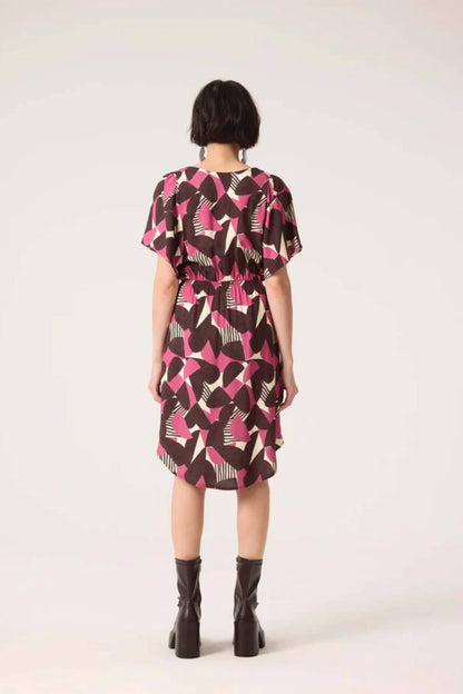 Back view of a woman wearing the Gemma Dress by Cokluch in Half Moon Berry print, standing in front of a white background