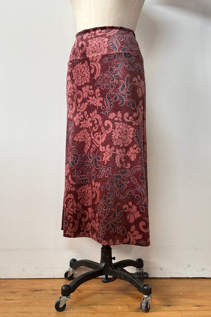 The Kollontai Winslet skirt, a burgundy velvet midi skirt, is shown on a mannequin against a white background. 