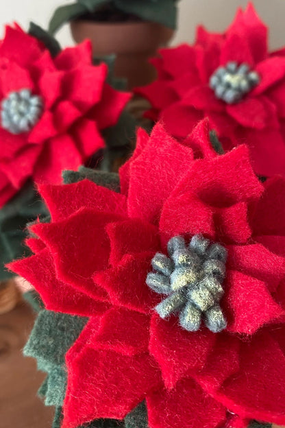 A close up of the Holiday Felt Poinsettia by ForgetBKnot.