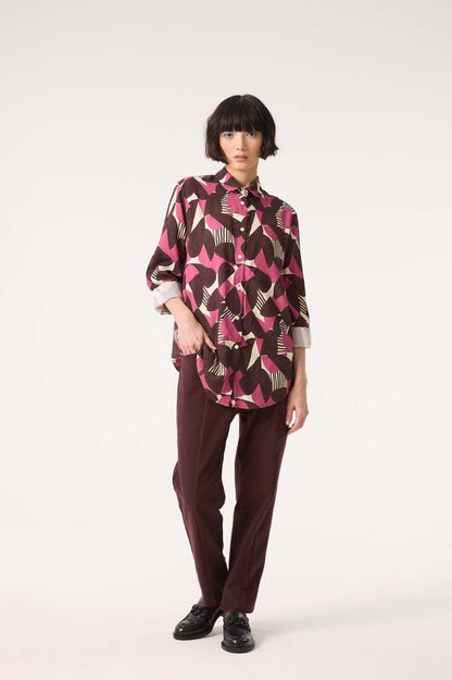 A woman wearing the Frontiers Shirt by Cokluch in Berry Half Moon print with the Belief Pants in Shiraz, standing in front of a white background 