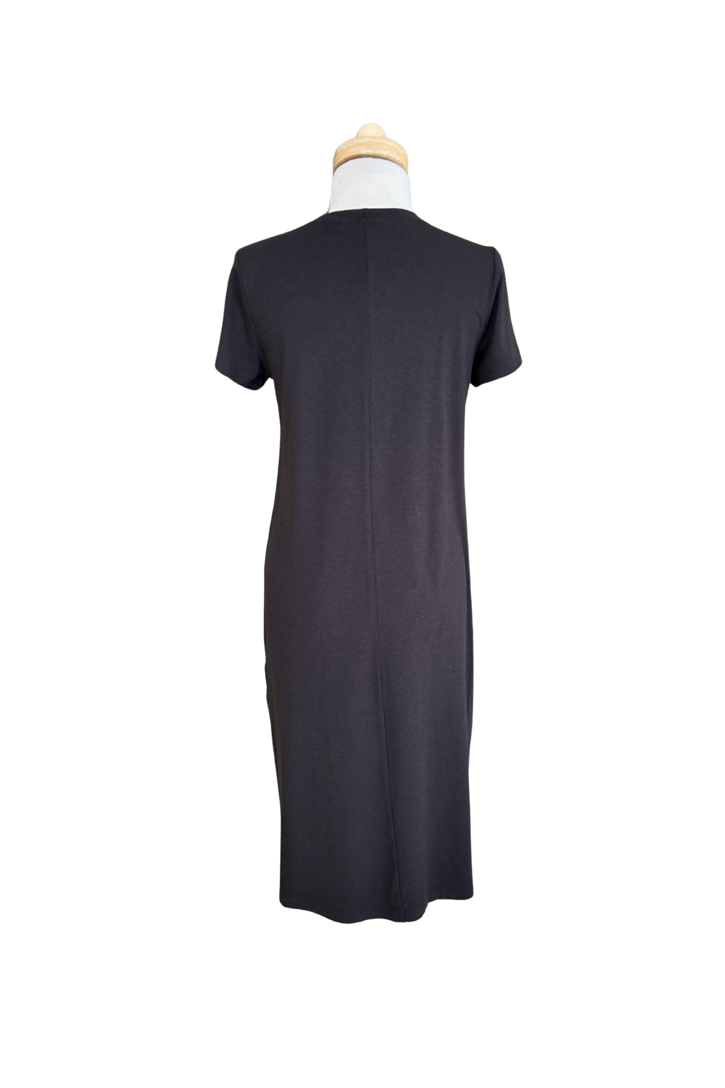 A back view of the Frances Midi  by Tangente in Black, a short sleeved loose fitting dress with side slits, is shown on a mannequin against a white background. 