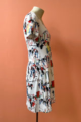 United Dress by Yul Voy, side view, watercolour city-scape print on white background, v-neck, short sleeves, fit and flare shape, above the knee, sizes XS to XXL, made in Montreal 