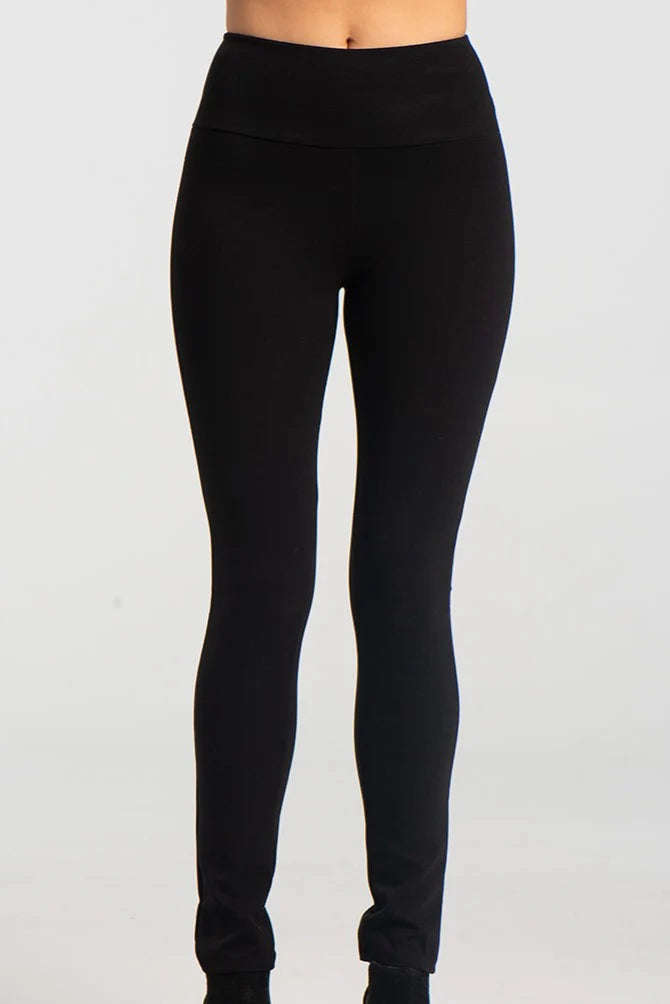 A waist down view of the Ella Pants from Kollontai in Black, slim pants with a wide pull on waistband, are shown against a grey background. 