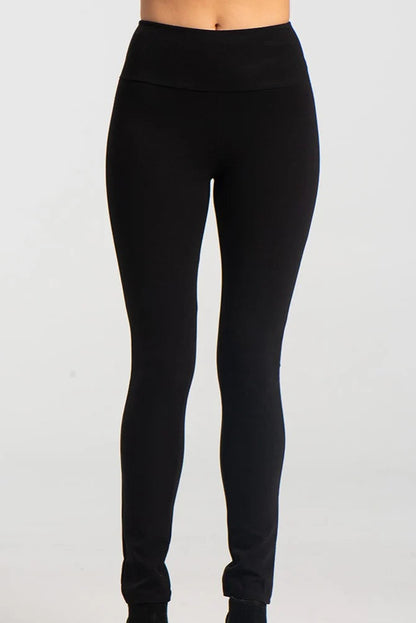 A waist down view of the Ella Pants from Kollontai in Black, slim pants with a wide pull on waistband, are shown against a grey background. 
