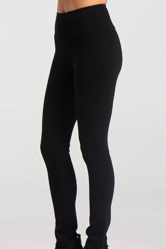 A waist down view of the Ella Pants from Kollontai in Black, slim pants with a wide pull on waistband, are shown against a grey background. 