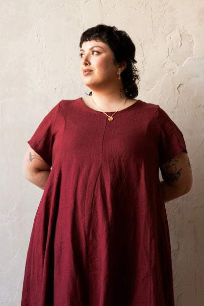 A woman wearing the Astoria Dress by Lights of All in Garnet