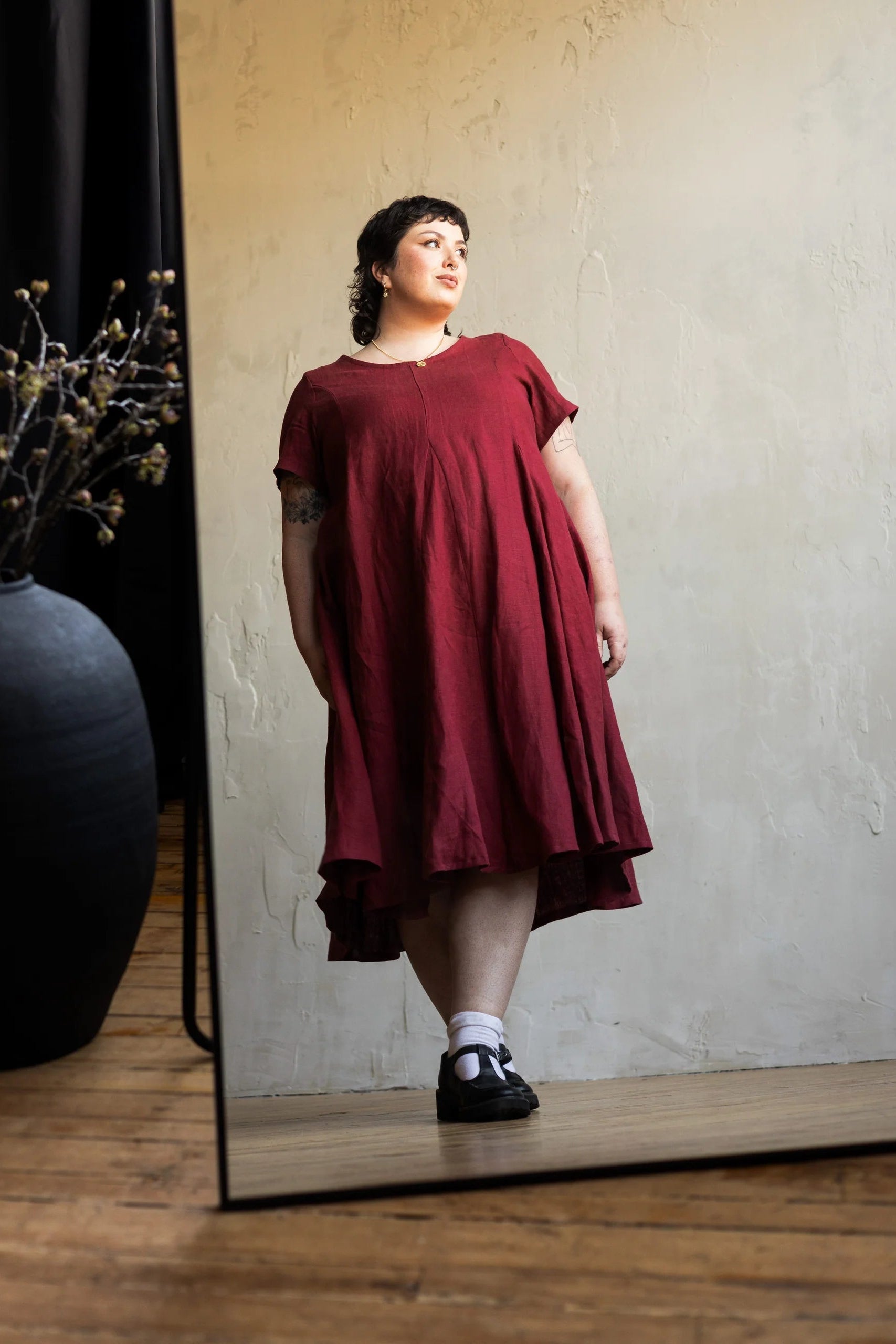 A woman wearing the Astoria Dress by Lights of All in Garnet