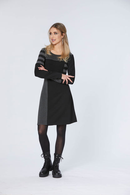 A woman wearing the Shift Dress by Luc Fontaine in Grey/Black, standing in front of a white background 