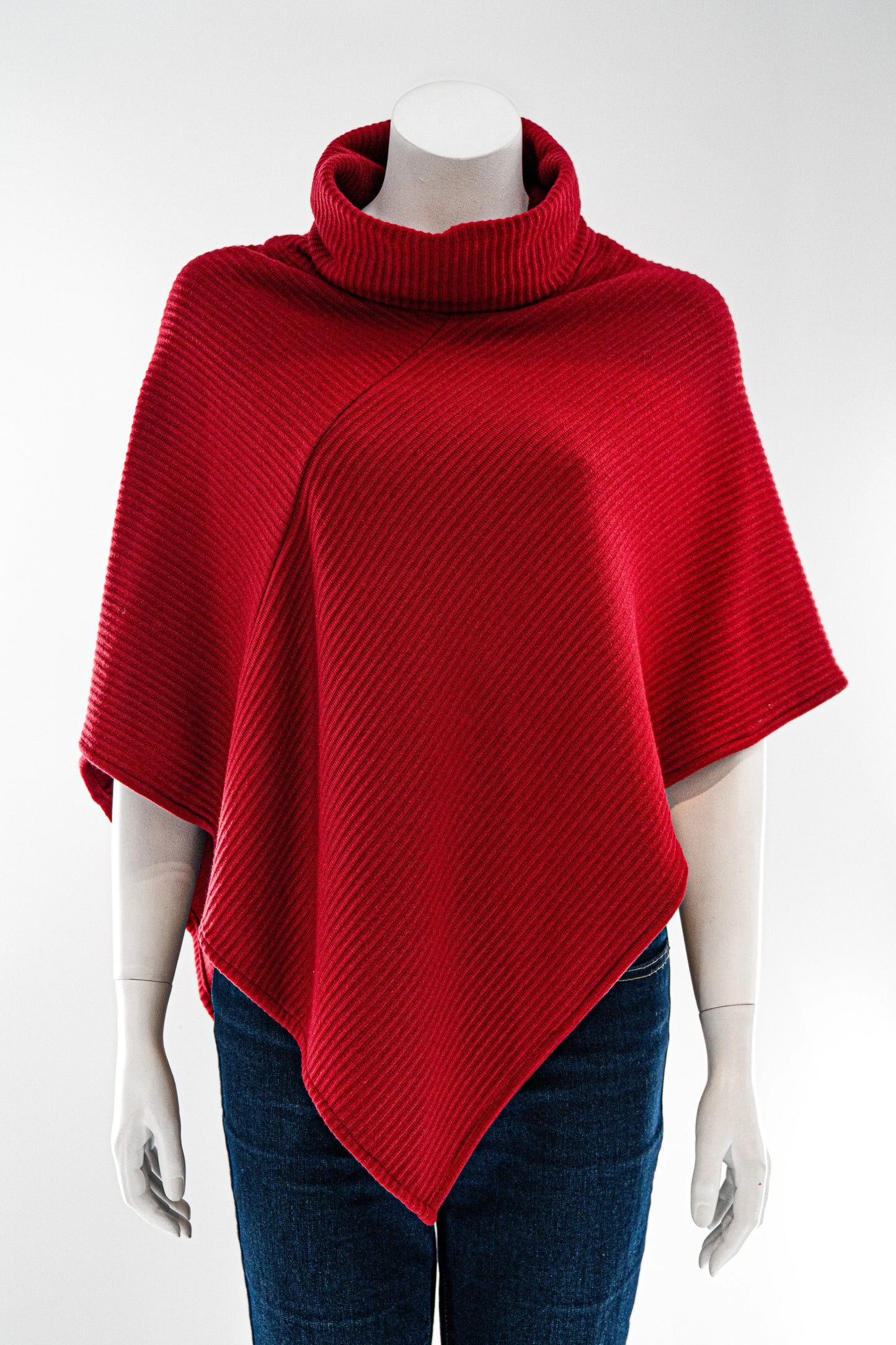 The winter Poncho by Karkass in Red, with a large turtleneck and angled hem, is shown on a mannequin against a white background