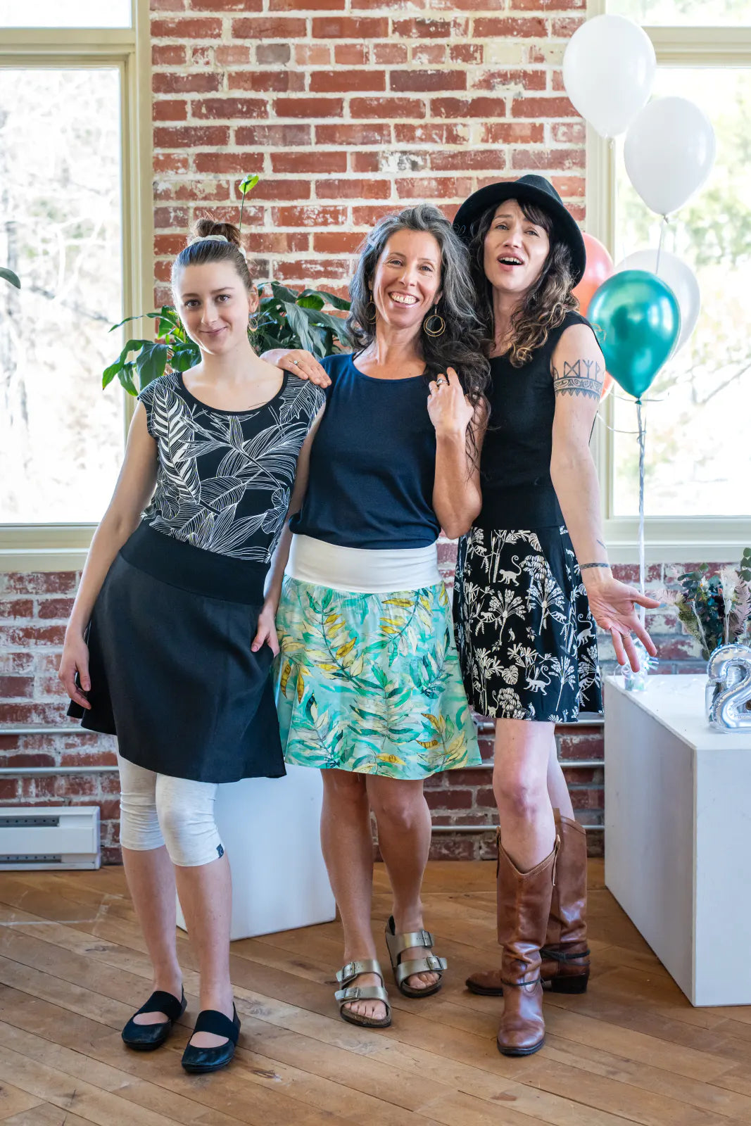 Three women wearing the Soleil Skirt by Marie C, with Sol Tops, standing indoors at a party. 