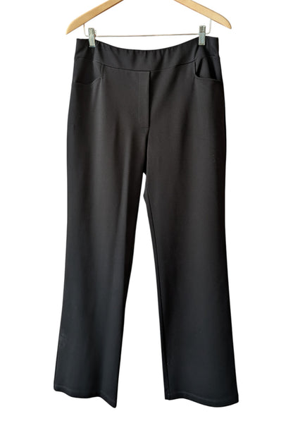 The Freddie Pants by Pure Essence in Black, pull-on pants with a wide, smooth waistband, straight legs, and front pockets, are shown hanging in front of a white background. 