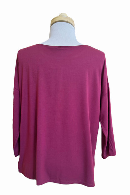 A back view of the Emmy Top by Moovment in Burgundy, with a boat neck, 3/4 sleeves, and side slits, is shown on a mannequin in front of a white background. 