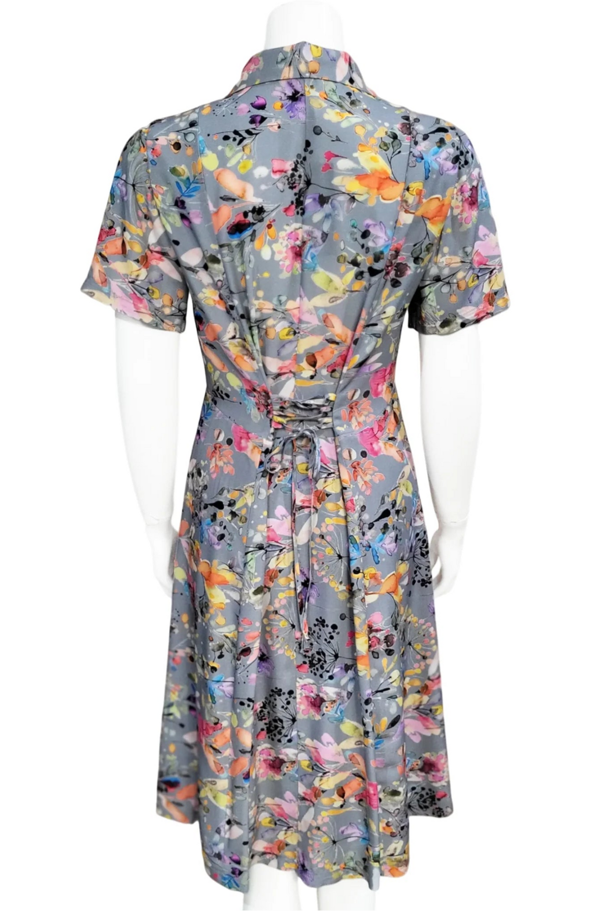 The Eloise Foliage Dress by Mandala in Grey, a short-sleeve collared dress with a vibrant print and a flared knee-length skirt, is shown on a mannequin against a white background.
