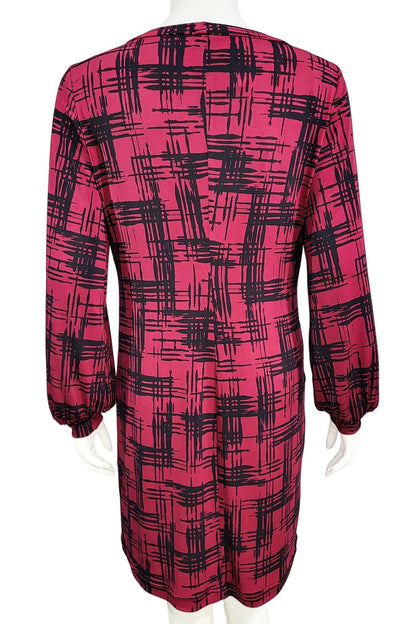A back view of the Gwyneth mini dress from Mandala in Hopscotch - Cherry is shown on a mannequin against a white background 
