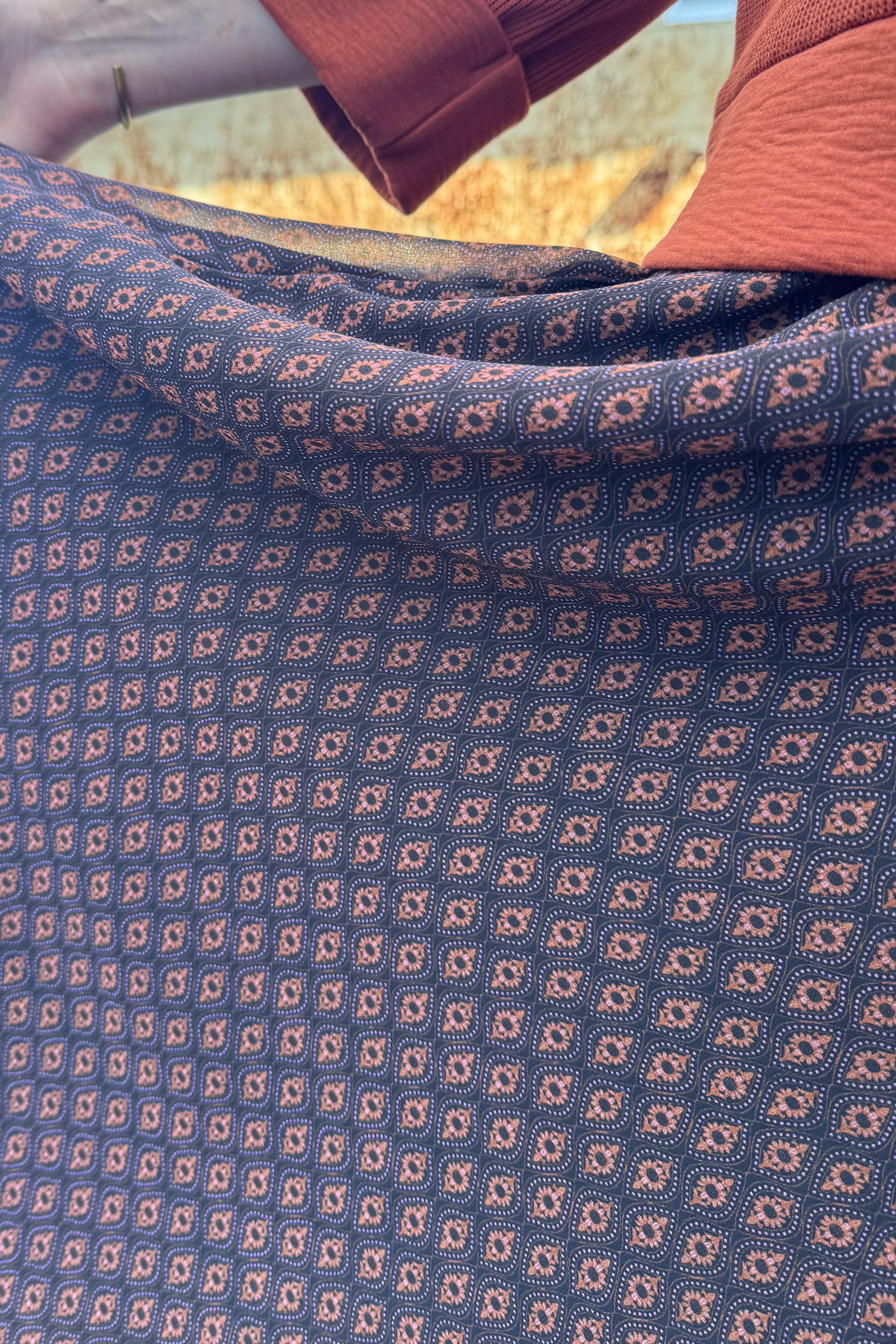 Close up showing the fabric detail of the A woman wearing the Espresso Skirt by Cherry Bobin in Black and Brown print.