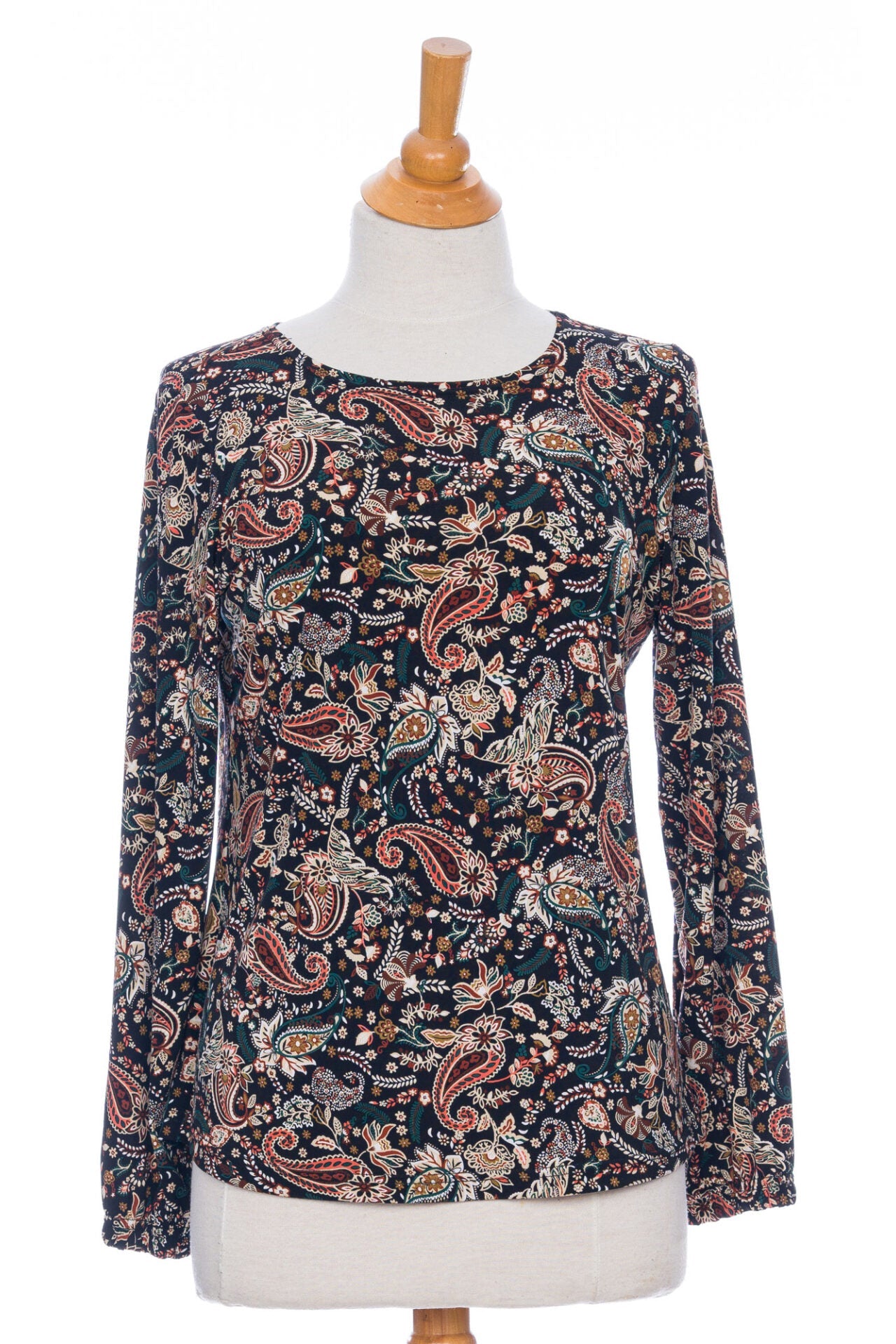 The Bruyère Sweater by Rien ne se Perd in Autumn Paisley print, with a round neck, relaxed fit, and long sleeves with cinched cuffs, is shown on a mannequin in front of a white background. 