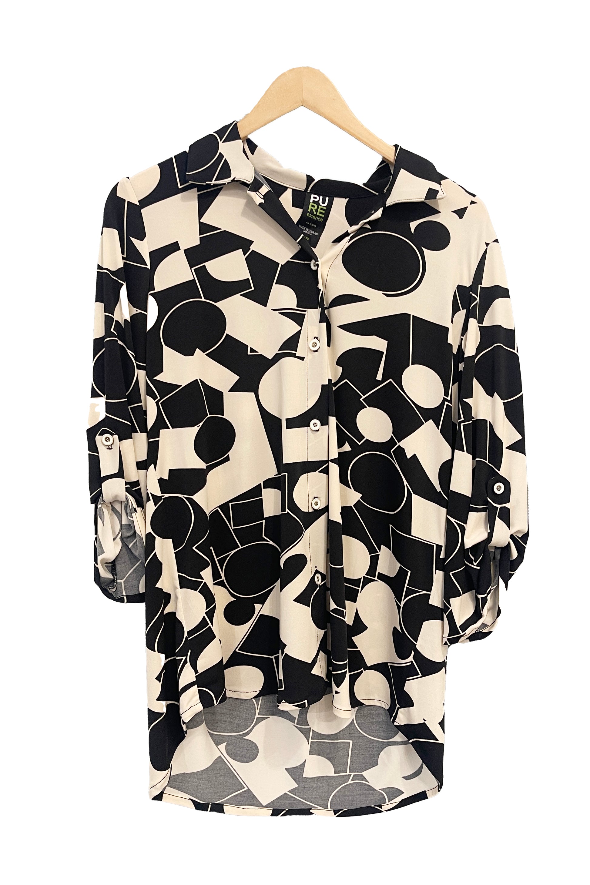 The Francesca Blouse by Pure in Black/Ivory geometric print, an oversized blouse with a lapel collar, button front, 3/4 sleeves with button and tab detail, and rounded h-low hemline, is shown hanging against a white background. 