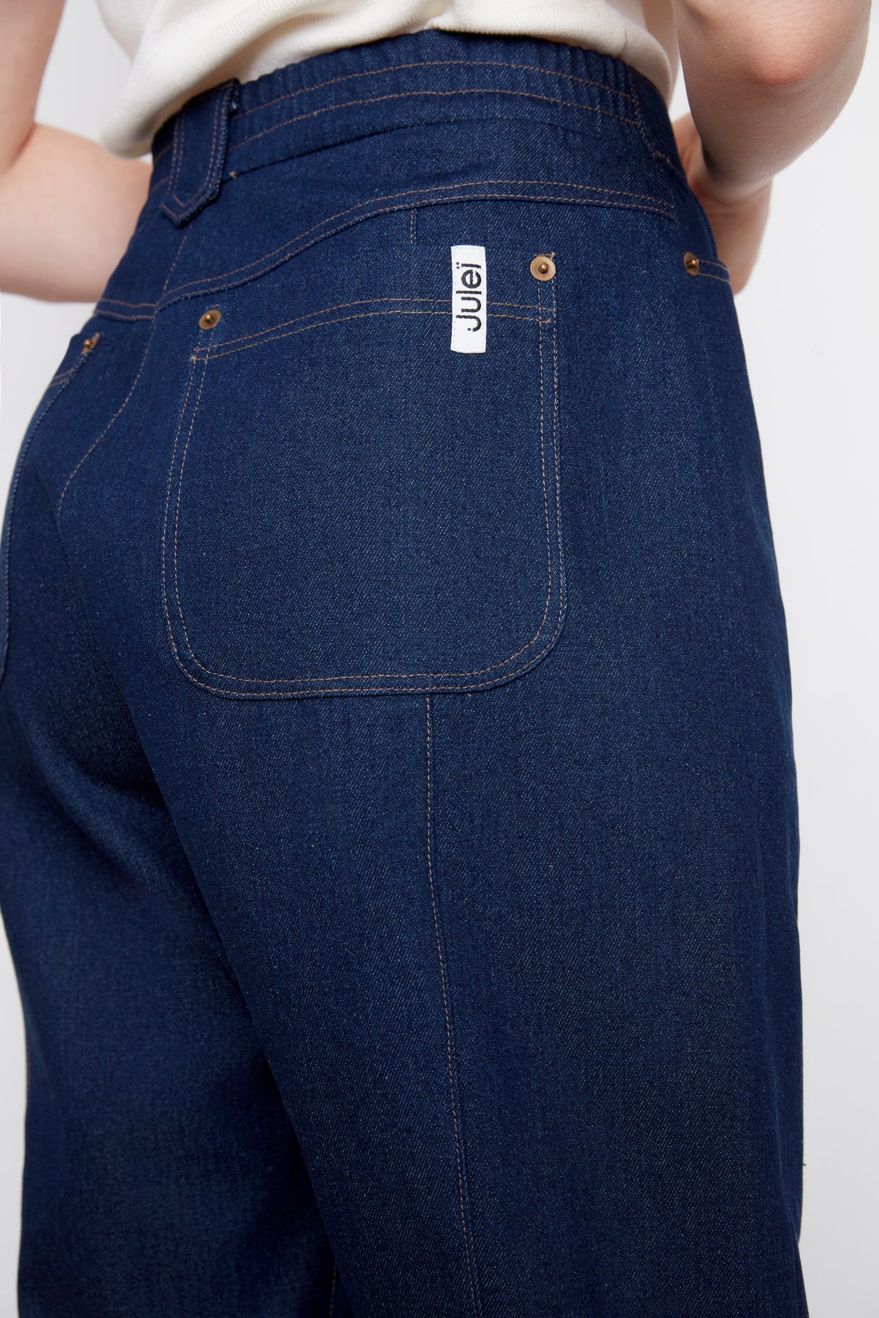 Close up of the back waist and leg of the A woman wearing the Alice Straight Leg Jeans by Julei in Dark Denim.