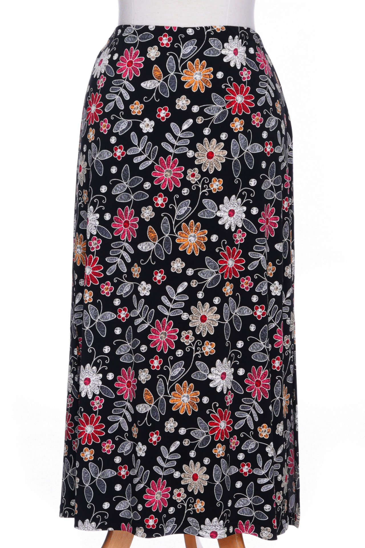 The Fiesta 7/8 Skirt by Rien ne se Perd in Colourful Daisies, a slightly A-line skirt with an elastic waist and side slits, is shown on a mannequin against a white background 