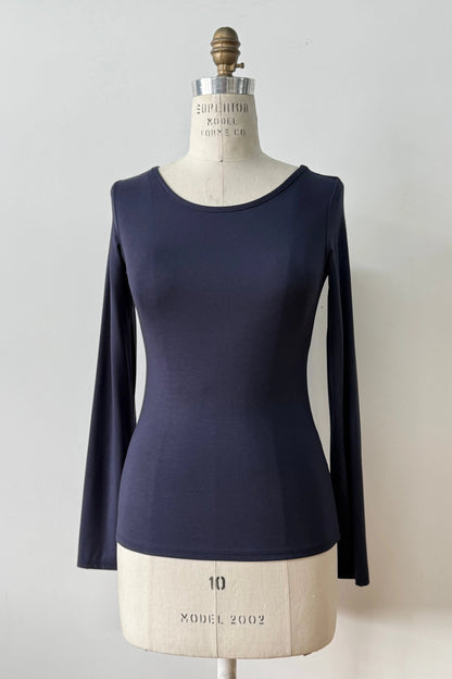 The Loretto Top by Kollontai in Navy, a slim fitting long sleeved top with a round neck, is shown on a mannequin against a white background. 