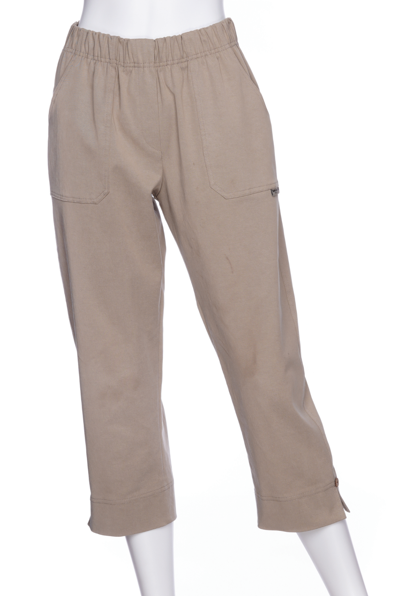 The Vino 3/4 Pants from Rien ne se Perd in Natural, elastic waisted pants with large pockets, and slim 3/4 legs with side slits with coconut button details, are shown on a mannequin against a white background. 