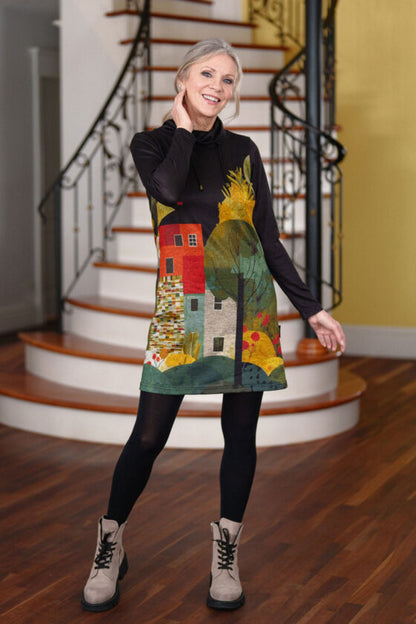 A woman wearing the Picasso Dress by Rien ne se Perd in a Landscape print, standing in front of a white staircase