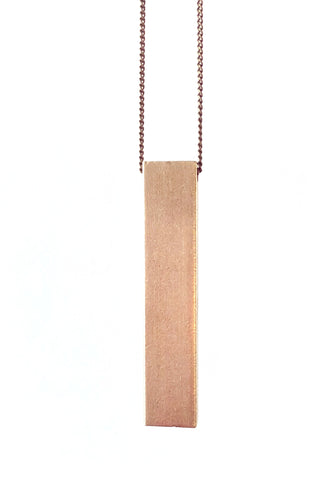 Blast necklace by Darlings of Denmark; closeup; long chain with a solid vertical bar; raw brass; flat lay