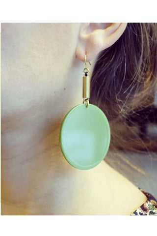 Flumme by Darlings of Denmark; dangle earrings; raw brass tubes with green acrylic circle details; worn to show approximate sizing