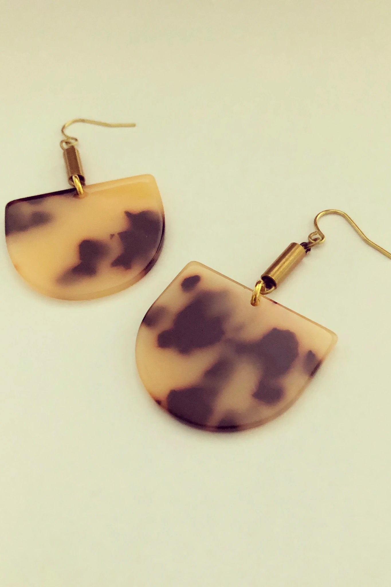 Ruve earrings by Darlings of Denmark; Acrylic, tortoise shell, semi-circle dangle earrings with short brass tube; raw brass and acrylic; flat lay